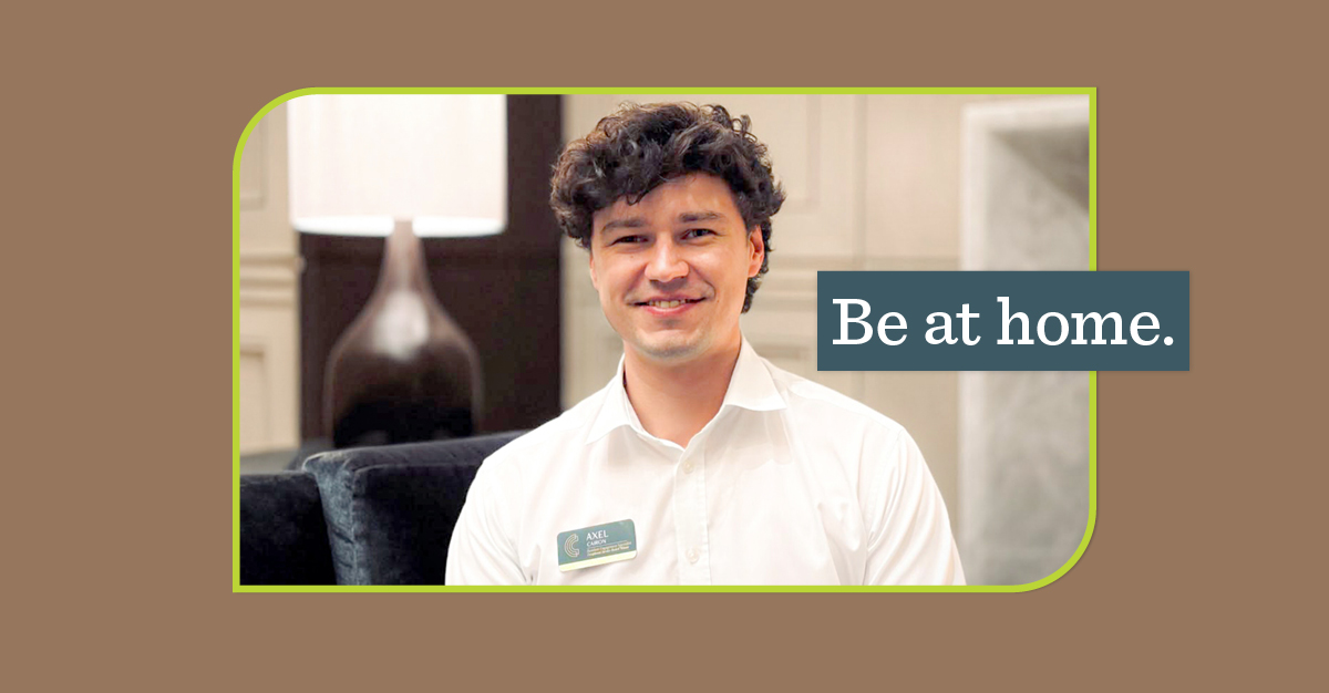 young man smiling wearing a collard shirt and name tag