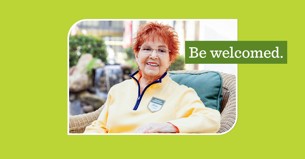 Older woman with red hair wearing a badge that says 